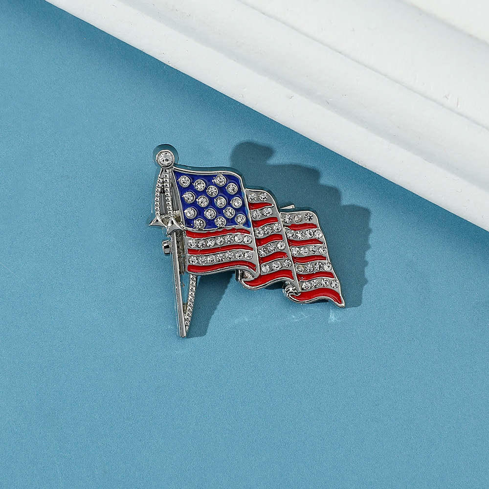 Broche alliage drapeau doré badge strass